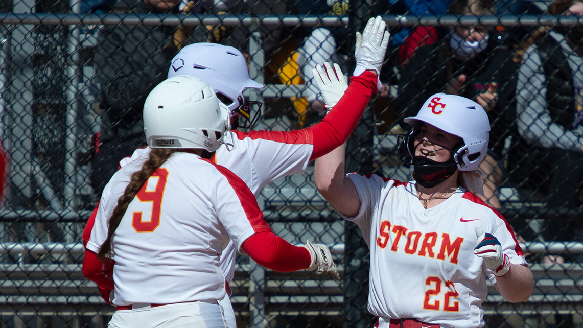 Simpson College softball player Sara Trent celebrates a home run with her teammates.